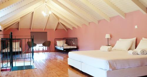 sypialnia z dużym białym łóżkiem i różowymi ścianami w obiekcie Kefalonia Private Paradise w Lixoúrion