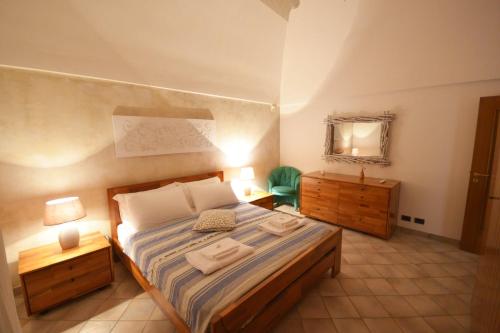 Villa Petra Chiara في لوكوروتوندو: غرفة نوم بسرير كبير مع مواقف ليلتين