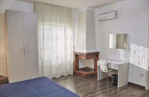 a bedroom with a bed and a desk and a fireplace at La Perla Del Sole in Corigliano Calabro