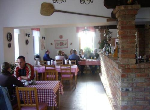 grupa ludzi siedzących przy stolikach w restauracji w obiekcie Bényei Fogadó Panzió és Étterem w mieście Erdőbénye