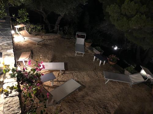 a group of chairs sitting on the ground at night at Villa Mariza in Scopello