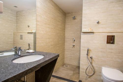a bathroom with a sink and a toilet at Mantris Hotel in Visakhapatnam