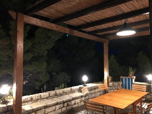 a wooden table and chairs under a wooden pergola at Villa Mariza in Scopello