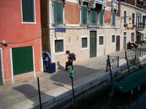 a person standing on a pole next to a canal at Appartamento con vista in Venice