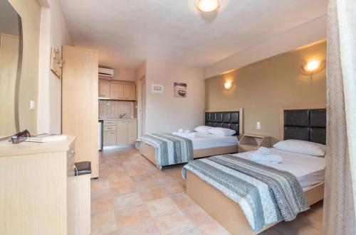 a hotel room with two beds and a kitchen at House Meltemi in Kalamitsi