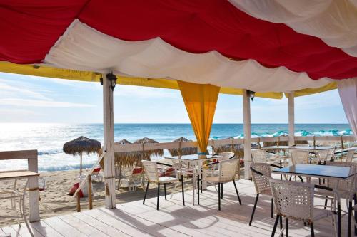 a restaurant on the beach with tables and chairs at Alice Apartment in Obzor