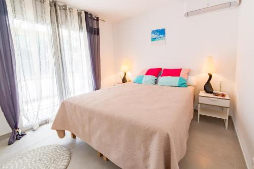 Un dormitorio blanco con una cama grande y una ventana en Le Valescure, en Saint-Raphaël