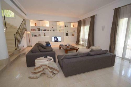 un salon avec deux canapés et une télévision dans l'établissement Villa 27A, à Ville du 6 Octobre