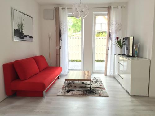 a living room with a red couch and a coffee table at Comfort Apartment Oldenburg in Oldenburg