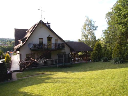a house with a large yard with a grass field at Willa Azalia in Polanica-Zdrój