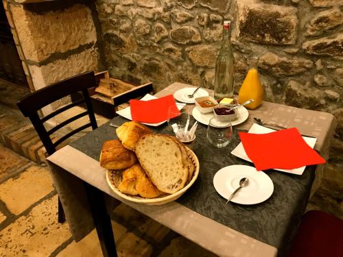 een tafel met een mand brood erop bij Aux Prisons de Montagny in Montagny