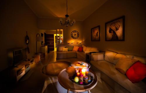 a living room with a couch and a table with candles at Petite Fleur in Preveza