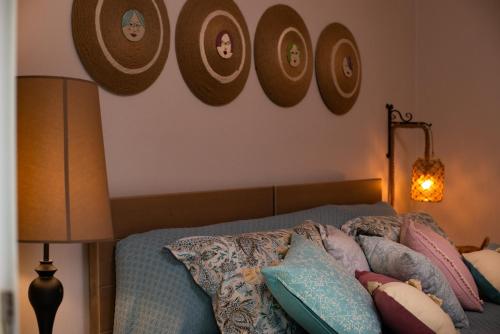 a bedroom with a bed with pillows and pictures on the wall at Petite Fleur in Preveza