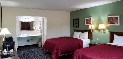 a hotel room with two beds and a window at Super 7 Motel in Sedalia