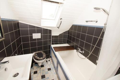 a small bathroom with a tub and a toilet at Ferienwohnungen BECKENDORF Schiller in Losheim