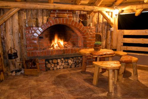 a brick fireplace in a room with a table and bench at Rtanjski konak in Boljevac