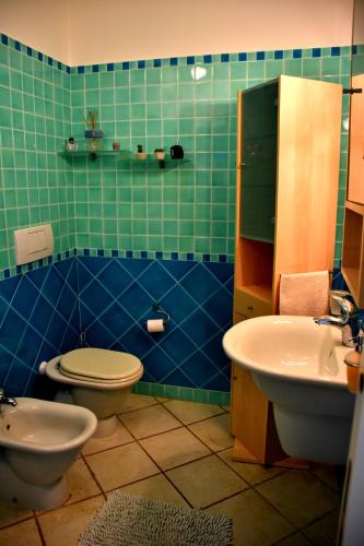 a green tiled bathroom with a toilet and a sink at Taormina Sunny Apartment - Taormina Holidays in Taormina