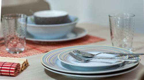 a table with plates and silverware on a table at Petite Fleur in Preveza