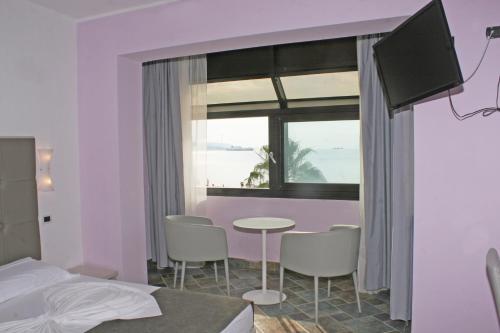 a bedroom with a table and chairs and a window at BB Oasis in Scilla