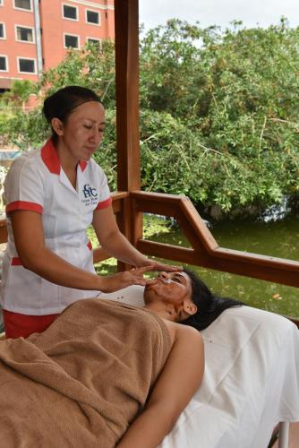 a woman is giving a woman a head massage at Gran Hotel De Lago - El Coca in Puerto Francisco de Orellana