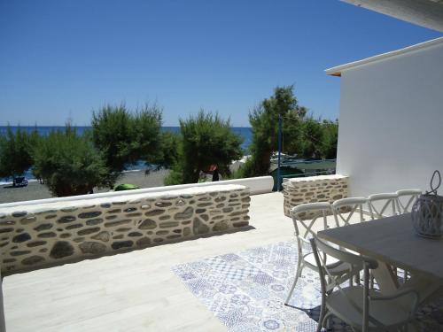 a patio with a table and chairs and a wall at Mythos Suites Diskos in Léntas