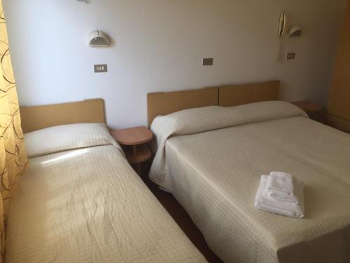 En eller flere senge i et værelse på Hotel Rimini