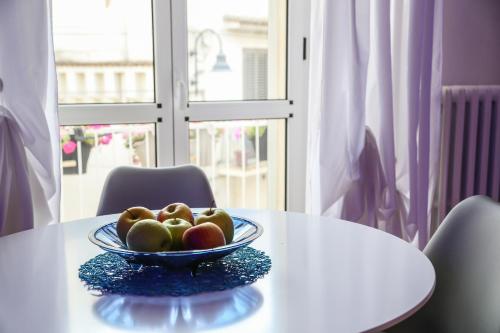 a bowl of fruit on a white table with a window at The Bridge Suites in Gravina in Puglia