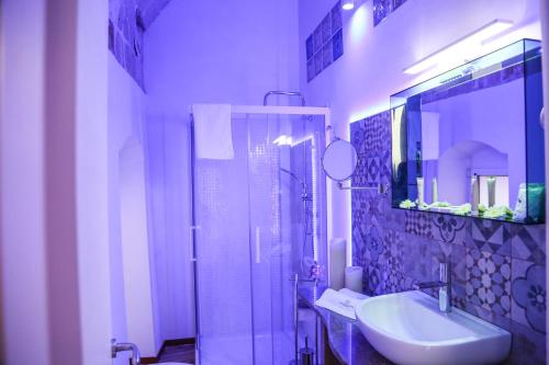 a bathroom with a sink and a shower with a mirror at The Bridge Suites in Gravina in Puglia
