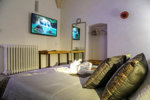 a bedroom with a bed with a tv on the wall at The Bridge Suites in Gravina in Puglia