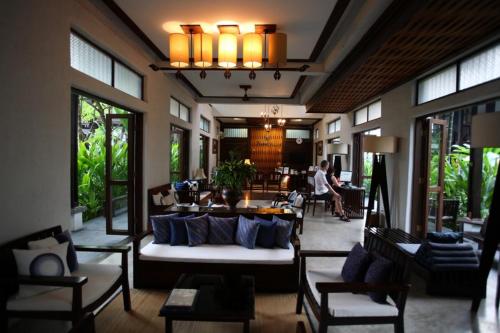 a lobby of a hotel with a couch and chairs at Banthai Village in Chiang Mai