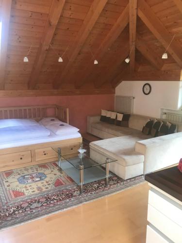 um quarto amplo com 2 camas e um sofá em Villa Pircher em Dobbiaco