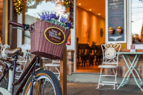 a bike parked next to a basket with flowers in it at Petit Casa da Montanha in Gramado