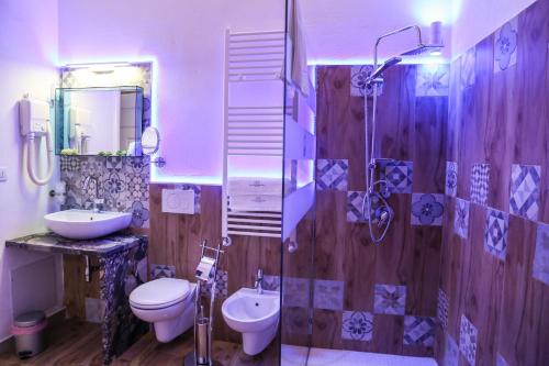 a bathroom with a toilet and a sink and a shower at The Bridge Suites in Gravina in Puglia