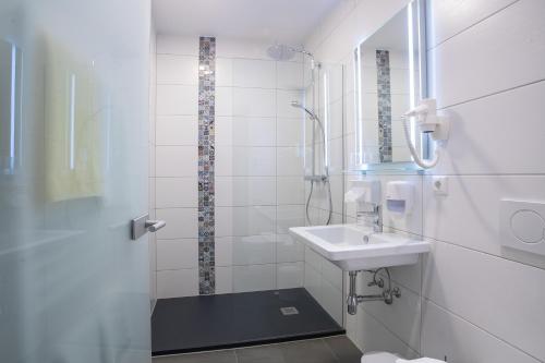 a white bathroom with a sink and a shower at ALPENHOTEL TYROL - B&B - ADULTS ONLY - Alpines Lifestyle-Konzepthotel - dog friendly in Pertisau