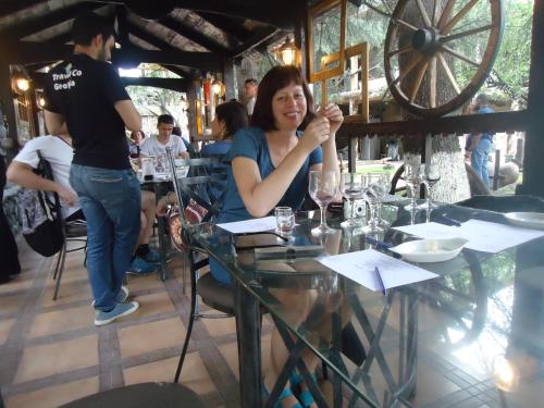 kobieta siedząca przy stole w restauracji w obiekcie Guest House R&T w mieście Tbilisi City