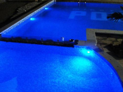 a blue swimming pool with blue lights on it at Family Hotel BOHEMA in Ognyanovo