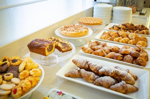 a table full of different pastries and desserts on plates at International Beach Hotel in Caorle