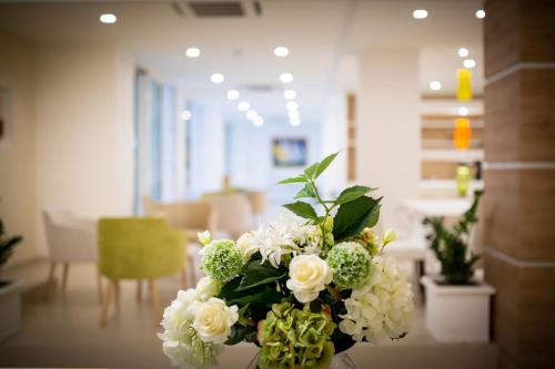 a vase filled with white flowers on a table at International Beach Hotel in Caorle