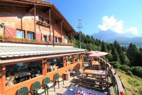 a building with tables and chairs on a mountain at Baita Zeni Tirolerhof - Adult friendly in Fiera di Primiero