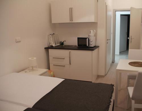 a small white kitchen with a microwave and a counter at Hauptbahnhof S2 in Vienna