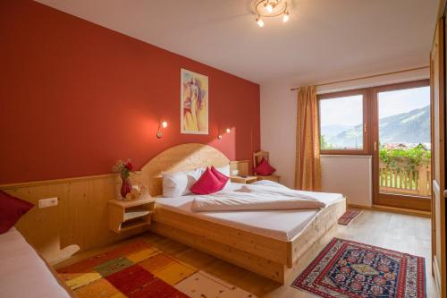 a bedroom with a bed and a large window at Landhaus Gasser in Mayrhofen