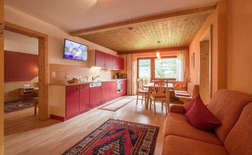 a kitchen and living room with a couch and a table at Landhaus Gasser in Mayrhofen