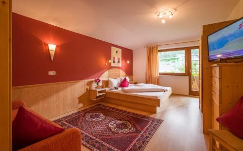 a room with a bed and a flat screen tv at Landhaus Gasser in Mayrhofen
