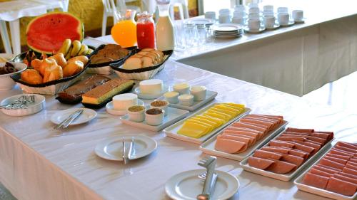 um buffet de comida numa mesa com frutas e legumes em Hotel Pinheirinho em Curitiba