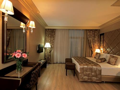 ブユクツェクメツェにあるエセル プレミアム ホテル & スパのベッドとデスクが備わるホテルルームです。