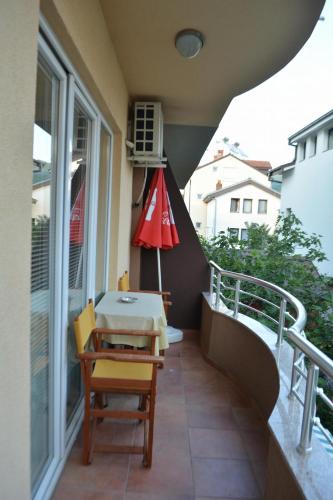 a balcony with a table and a red umbrella at Apartments Elena in Ohrid