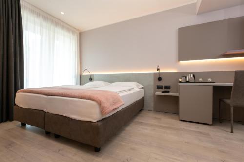 a bedroom with a bed and a desk and a window at Garda Life in Riva del Garda
