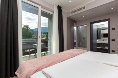 a bedroom with a bed and a large window at Garda Life in Riva del Garda