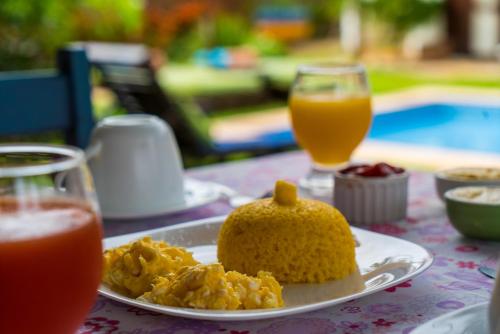 a plate of food on a table with drinks at Villa Albergaria in Flecheiras
