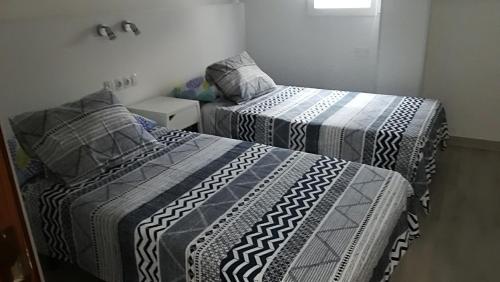 twee bedden in een kleine kamer met bij casa quintana in Arinaga